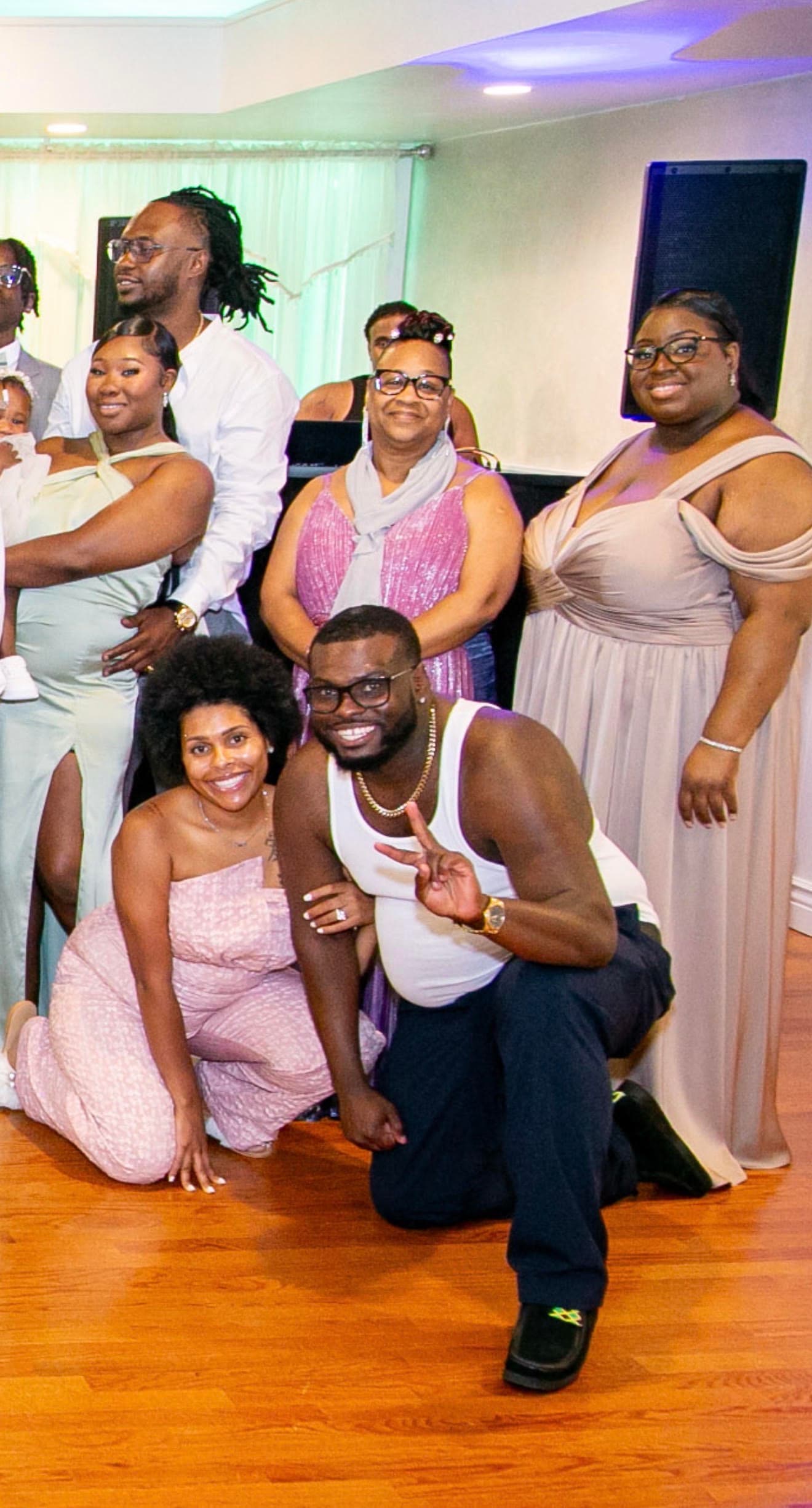 A group of smiling Black people posing together at an indoor celebration or party.